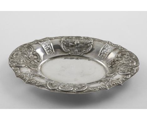 AN EDWARDIAN PIERCED DISH. of shaped oval outline, with an embossed scroll border and decorated in relief on the sides with f