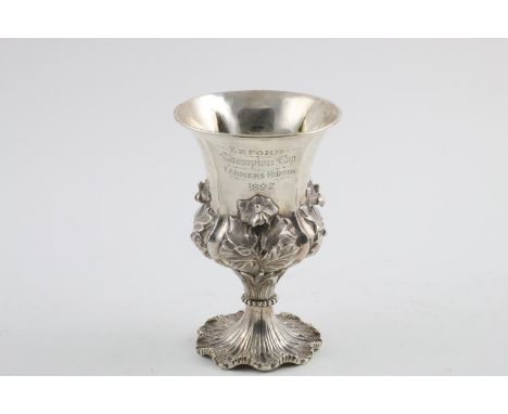 A WILLIAM IV GOBLET. the body embossed in high relief with flowers and leaves, the stem with simulated reeds and a beaded sur