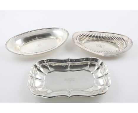 BY TIFFANY &amp; CO:-. an early 20th century navette-shaped bread basket, with a reeded border, together with another example