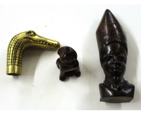 A brass walking cane head in the form of a crocodiles head; together with a carved wooden Netsuke in the form of a seated dog