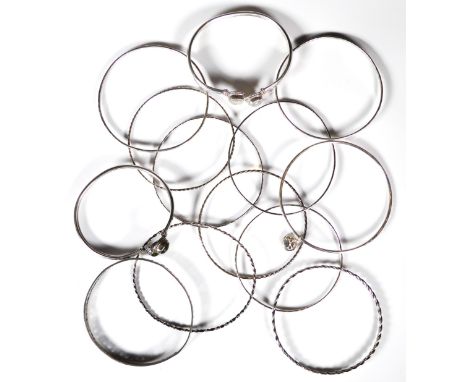 A collection of silver bangles - including a torc style bangle set with two cabochon moonstones; a similar bangle set with pe