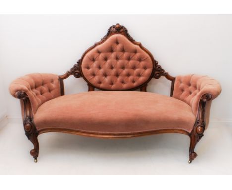 A large, fine and showy mid-19th century carved walnut and upholstered buttonback sofa of generous proportions: the finely ca