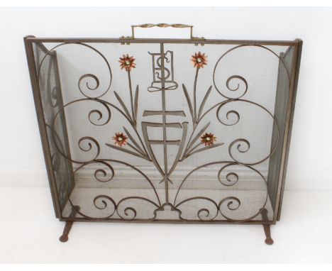 An Arts and Crafts style wrought-iron and wire-mesh folding fire screen: barleytwist brass handle; wrought-iron scrolls and&n