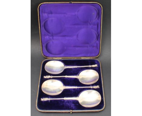A cased set of four hallmarked silver serving spoons; each with engraved scrollwork-style decoration to the stem leading to a