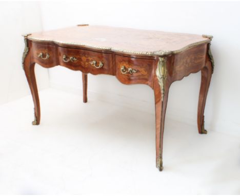A Louis XVI style kingwood, rosewood, mahogany and marquetry serpentine bureau-plat: fourth quarter 20th century; the top wit