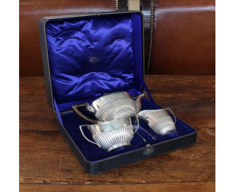 A three-piece hallmarked silver tea service in Georgian style in its original fitted case.&nbsp;Each piece with reeded lower 