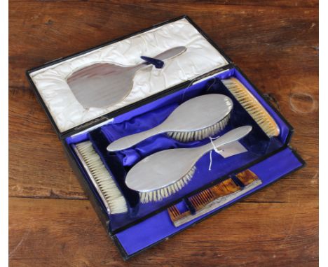 An early 20th century six-piece silver-mounted dressing table set comprising: two hairbrushes; two clothes brushes; a silver-