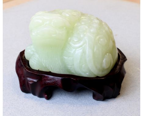 A 20th century Chinese carved pale celadon jade model of a bearded&nbsp;Karashishi with pointed ears, flying mane and bifid t