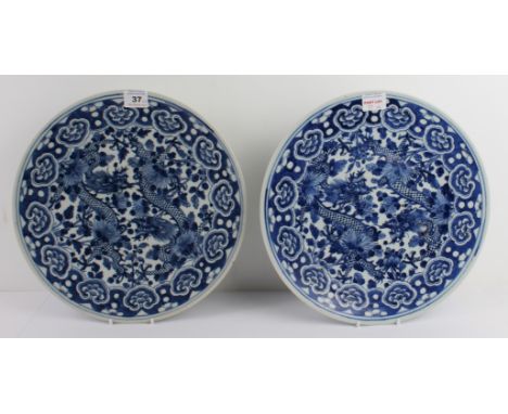 A pair of Chinese blue-and-white porcelain chargers: probably late 19th century, painted with two opposing long bodied, four-