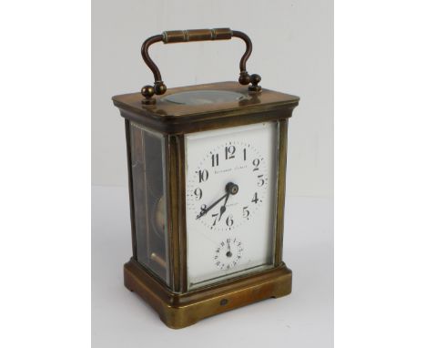 An early 20th century French glass-sided brass carriage clock: the white enamel dial (with crack) having Arabic numerals and 