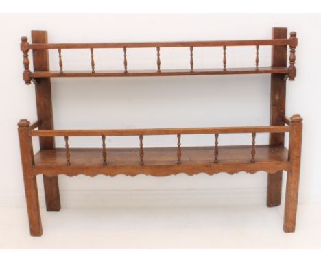 A 19th century continental oak two-tier dresser-style rack: both shelves with slender turned balustrades and the lower shelf 