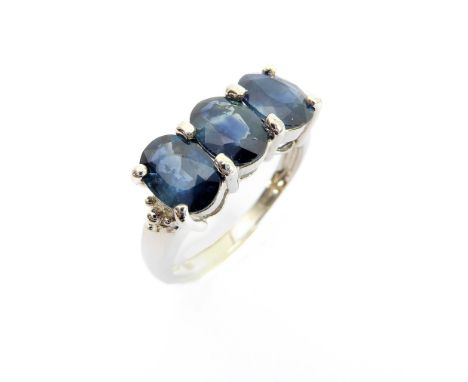 A 9-carat white gold dress ring: horizontally set with three hand-cut oval sapphires within claw mounts, ring size N/O (boxed