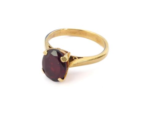 An 18ct yellow gold and pigeon blood ruby single stone ring - not marked, tests as 18ct, the approx. 7.5 x 6 mm oval cut ruby