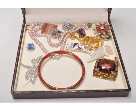 A group of vintage costume jewellery to include a silver horse and jockey brooch, a pair of Trifari made clip on earrings, cl