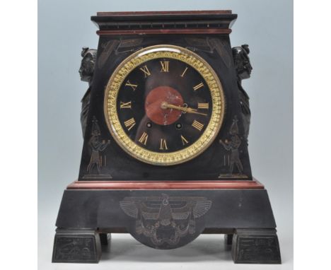 A early 20th Century Art Deco 1920's Egyptian Revival black slate and red marble mantel clock. The clock raised on brass supp