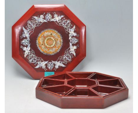 A 20th Century Chinese lacquered octagonal sectional wooden box having intricate mother of pearl inlay to the lid in the form