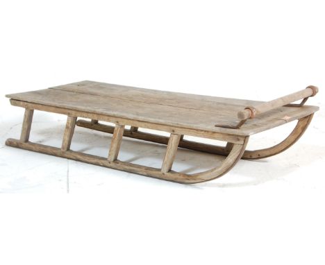 A vintage 20th Century scrubbed wooden sledge / sled / sleigh having a turned handle to the top and two runners to the base e