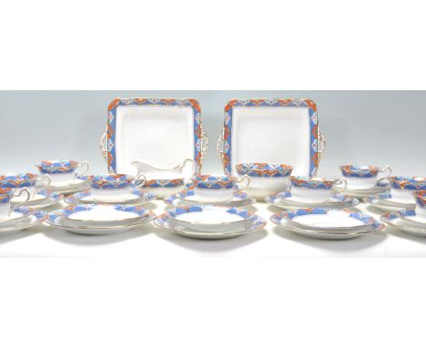 A Fine Bone China English tea service by Kildare Fenton China having blue ground rims with orange pattern decoration. The ser