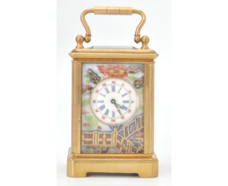A vintage brass cased miniature carriage clock with porcelain panels decorated with roses, having a round face with roman num