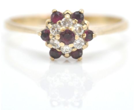 A 9ct gold ruby and diamond cluster ring. The ruby and diamond mixed cut stones in cluster setting on plain shank. Sponsors m