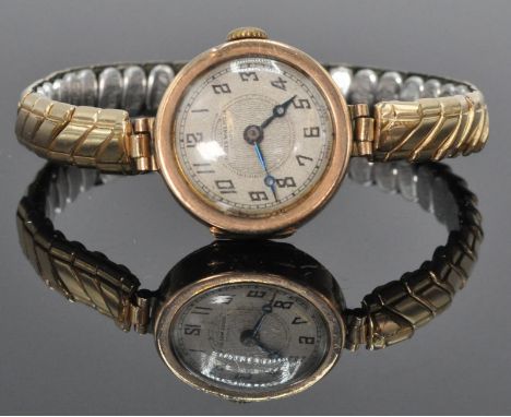 An early 20th Century Art Deco 9ct yellow gold ladies wrist watch having a decorative face with Arabic numeral chapter ring. 