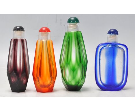 A set of 4 vintage faceted glass perfume bottles in various colours. Measures 9 cm long.&nbsp;