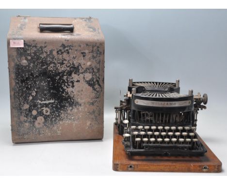 An early 20th Century Williams Academy Model typewriter having a black painted metal body with round white keys, complete in 