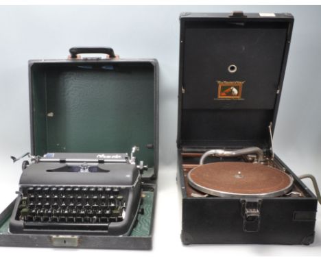 A vintage 20th Century Olympia typewriter having a black matte ebonised metal body with black typing keys, set within origina