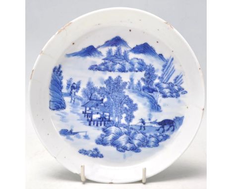 An 18th Century Kangxi Chinese blue and white hand painted dish of round form being finely painted depicting pagod's within a