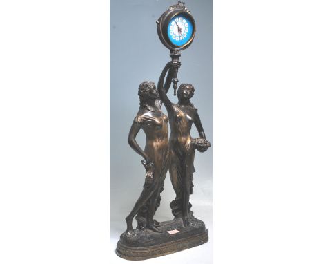 A large 20th Century antique style cast bronze figural mantel clock in the form of two classical female figures depicted hold