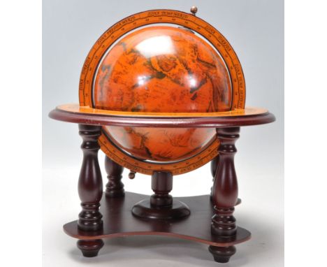 A Georgian style terrestrial desk globe supported in a wooden meridian ring and a finely decorated horizon ring, supported on