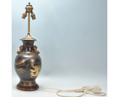 A good vintage Chinese brass table lamp having a black painted ground with dragon and cloud decoration. Red and green coloure