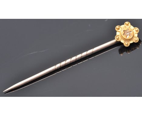 A 9ct gold toped tie pin having wire work and ball finial decoration set with a single diamond chip. Stamped 9ct. Total weigh