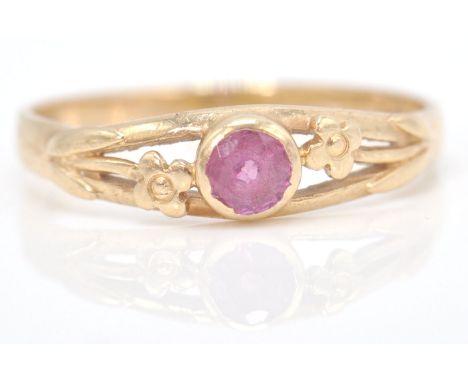 A hallmarked 9ct gold and ruby ring. The central mixed cut ruby in a pierced flower setting. Hallmarked for London, Sponsors 