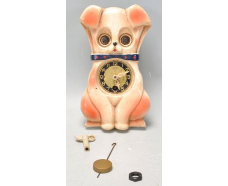 A vintage retro mid 20th Century Mi-Ken wall clock in the form of a dog having moving eyes. With pendulum.&nbsp;&nbsp;