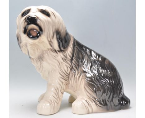 A 20th Century large glazed ceramic figure in the form of an Old English Sheepdog in a seated position with hand painted feat