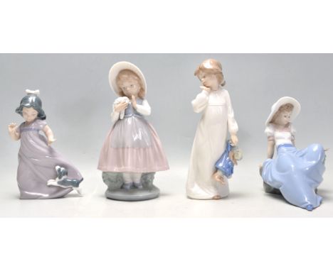 A group of four Nao porcelain figurines to include a seated girl with a perched bird, a girl in a night dress with a doll, a 