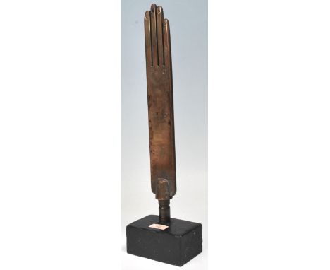 A vintage 20th Century rare glove makers glove mould having a metal body with four fingers mounds to the top, raised on an eb