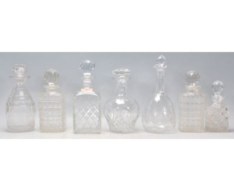 A group of seven vintage and antique cut glass decanters to include a pair of whiskey decanters with spherical stoppers, as w