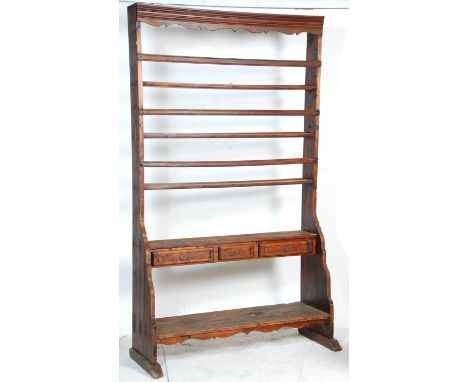 A 19th century Victorian large country stained pine open plate rack shelf wall unit having three sets of plate racks above a 