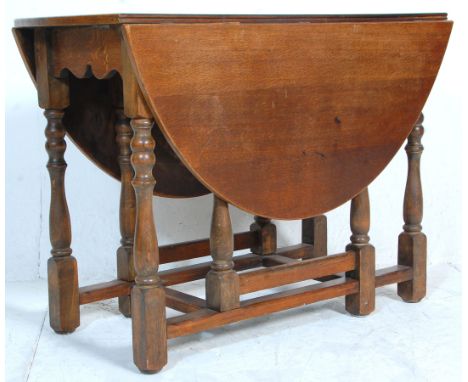 An early 20th Century country oak gate leg table raised on on block and turned legs suporting an oval oak top. Measures 77x13