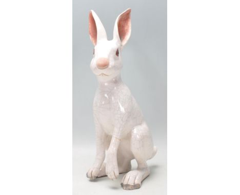 A vintage retro ceramic pottery figure in the form of a hare having a white crackle glazed finish and dark brown painted eyes