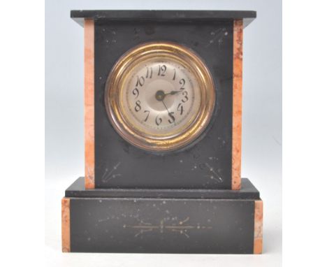 An early 20th Century slate and marble mantel clock having a silvered dial with Arabic numeral chapter ring. Engraved decorat