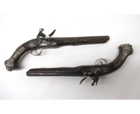 Pair of elaborate C18th century Turkish flintlock 20 bore holster pistols, 10" barrels heavily decorated with figures of men 