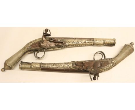 Pair of Balkan silver covered decorative flintlock pistols, 9.5" staged barrels, white metal wire bound grips and overlaid st