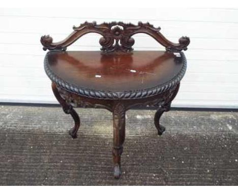 A demi lune console table with carved decoration on tripod supports, approximately 94 cm x 84 cm x 40 cm.