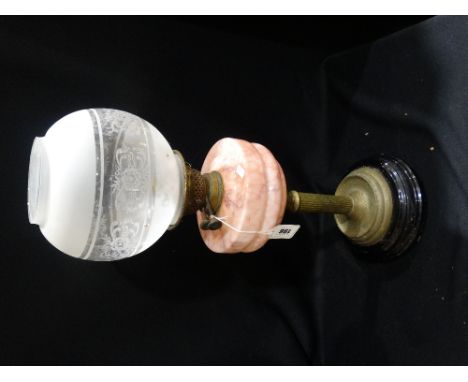 A Circular Based Brass Column Oil Lamp With Pink Tinted Reservoir