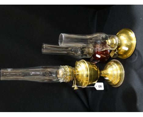 A Cranberry Tinted Glass Bedroom Oil Lamp, Together With Two Brass Oil Lamps