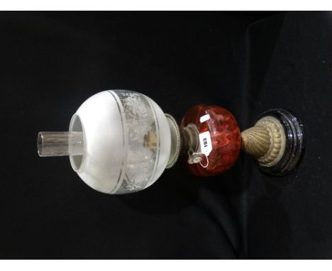 A Circular Based Brass Column Oil Lamp With Cranberry Tinted Reservoir