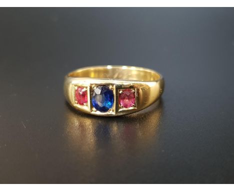 SAPPHIRE AND RUBY THREE STONE RINGthe central oval cut sapphire approximately 0.5cts flanked by smaller oval cut rubies total